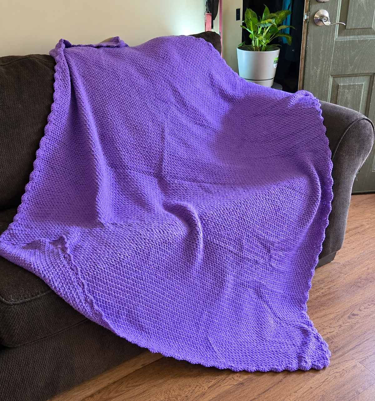 Lilac Breeze handmade crocheted afghan displayed on a sofa