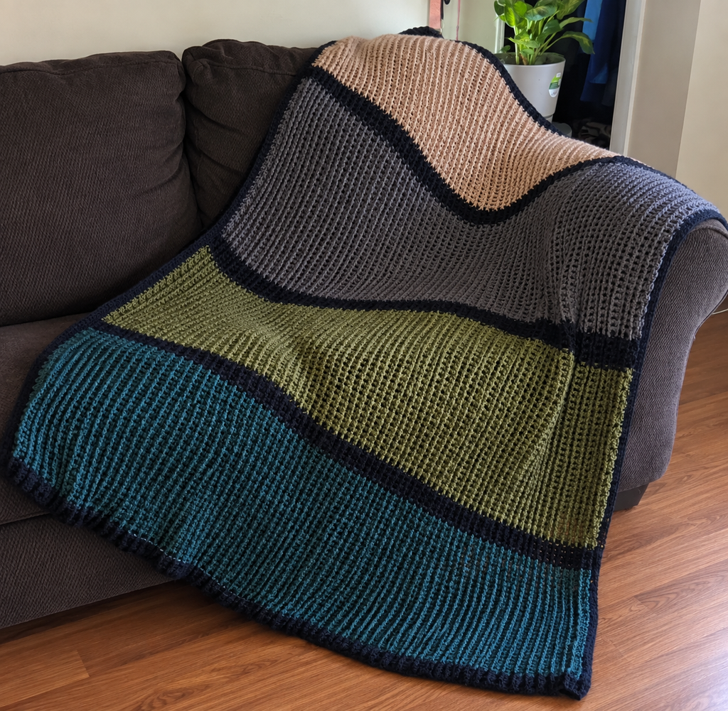 Midnight Harvest handmade crocheted afghan displayed on a sofa