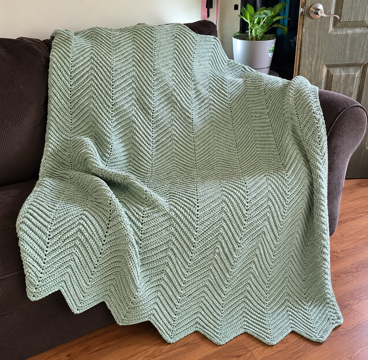 Sage Meadow handmade crocheted afghan displayed on a sofa
